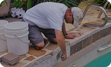 man remodeling pool tile and coping