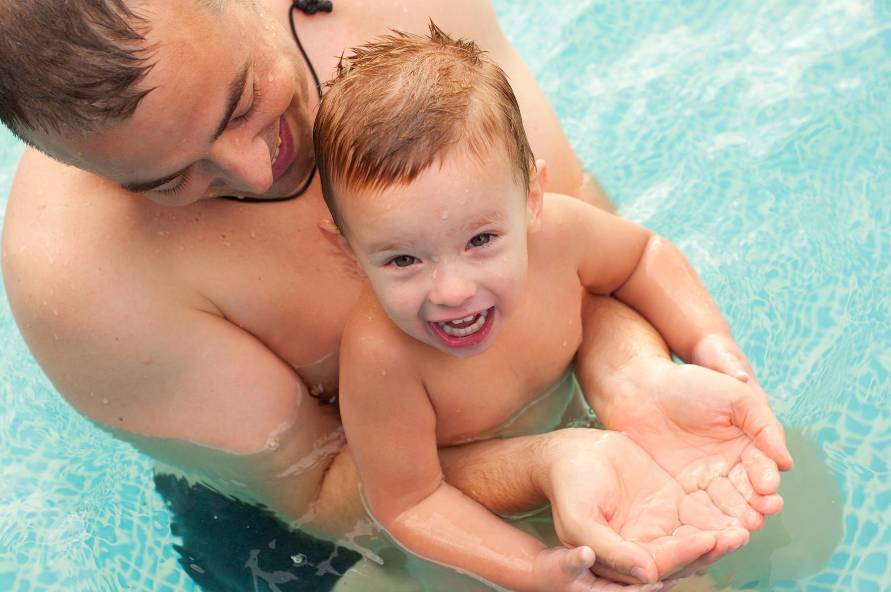 father and son playing in pool - Let's Talk About Pool Heaters