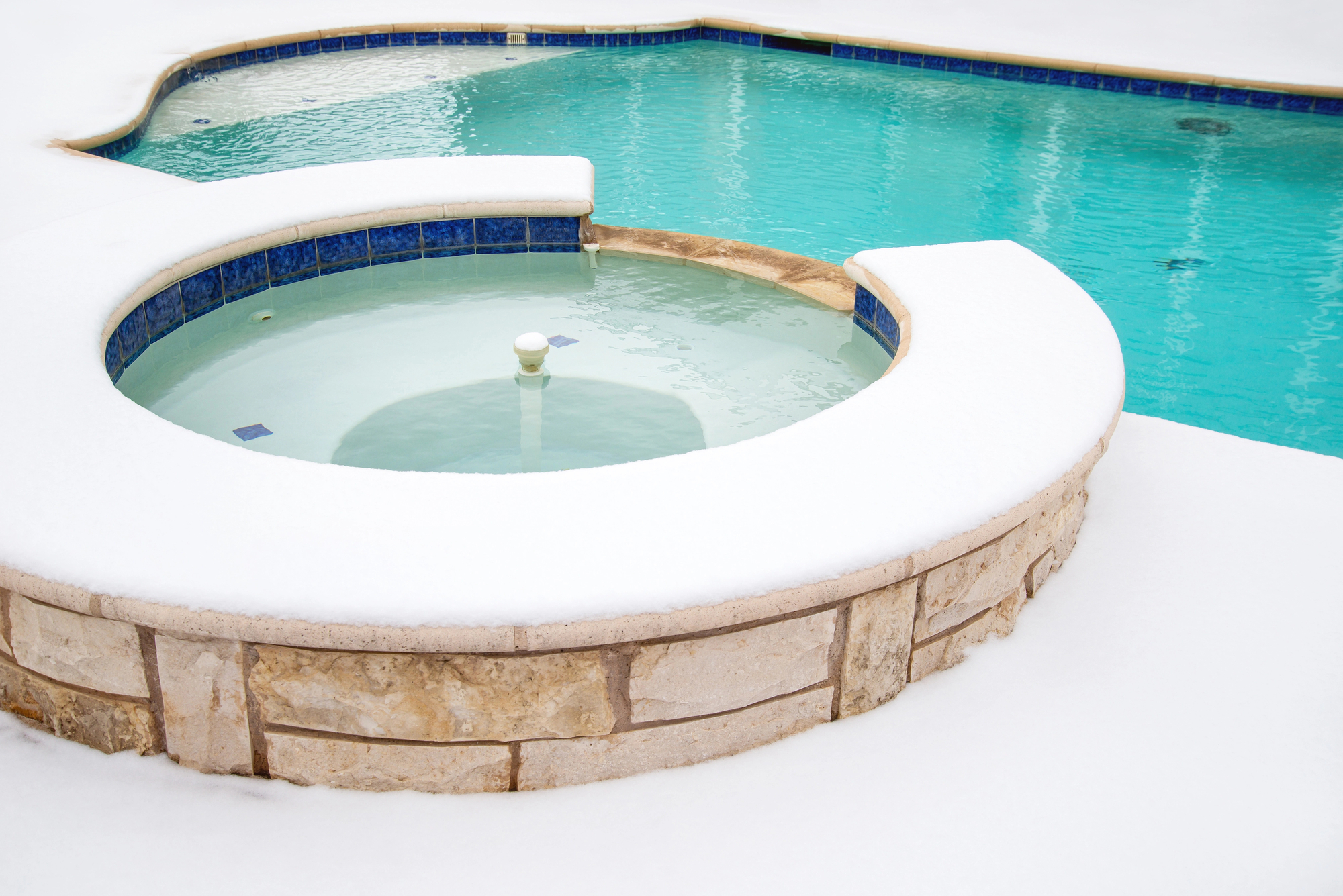 Snow-covered outdoor hot tub and swimming pool in winter